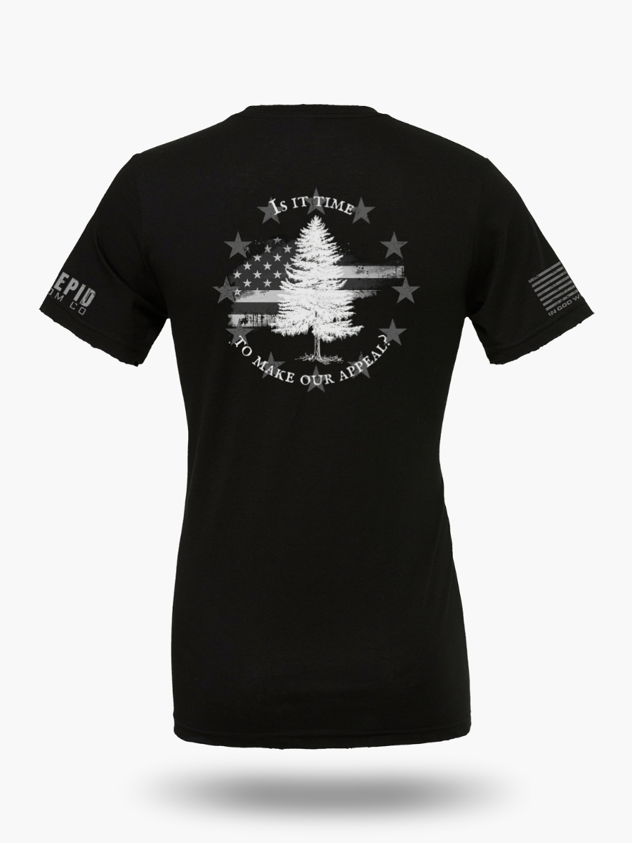 Black t-shirt with Appeal to Heaven flag design featuring a bold White Pine Tree over a distressed American flag background. Historic patriotic graphic with strong revolutionary symbolism.