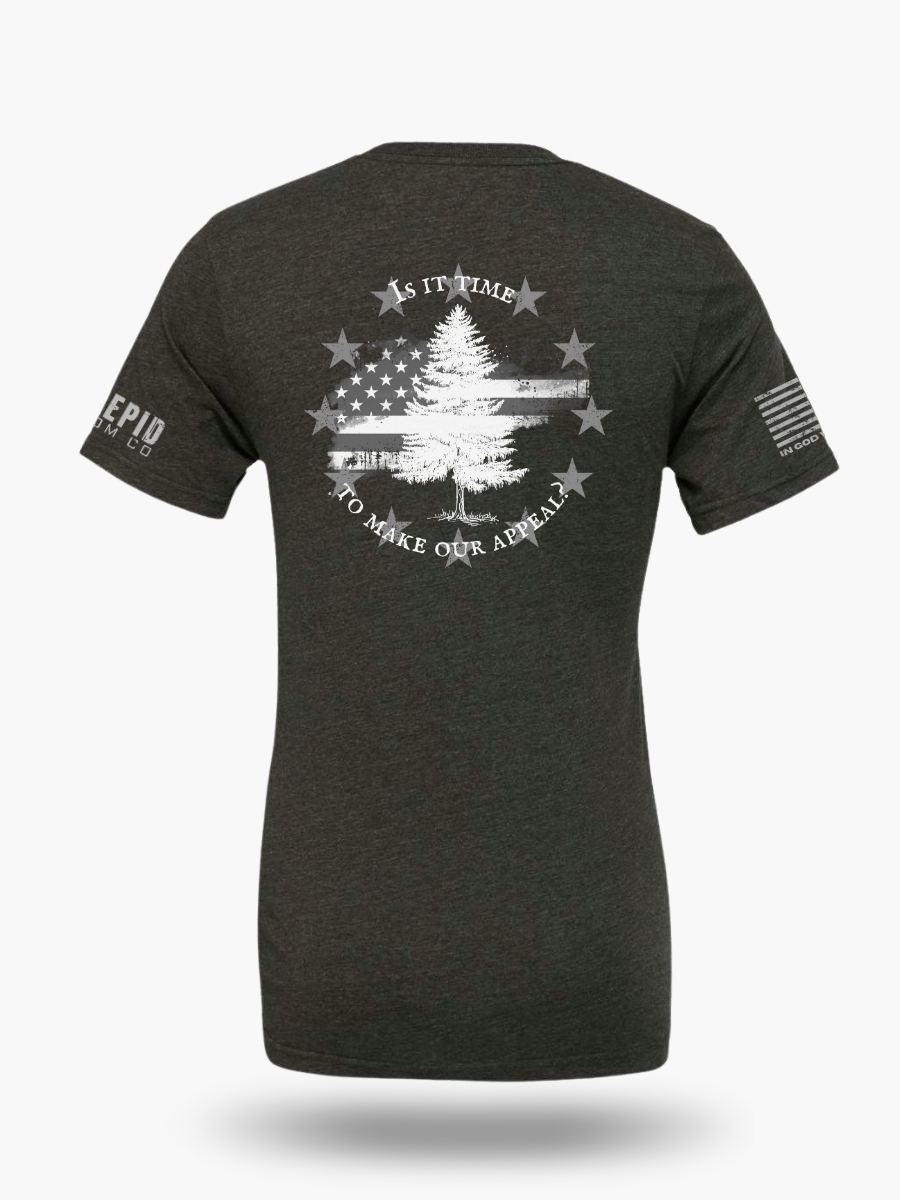 Dark heather grey t-shirt with Appeal to Heaven flag design featuring a bold White Pine Tree over a distressed American flag background. Historic patriotic graphic with strong revolutionary symbolism.