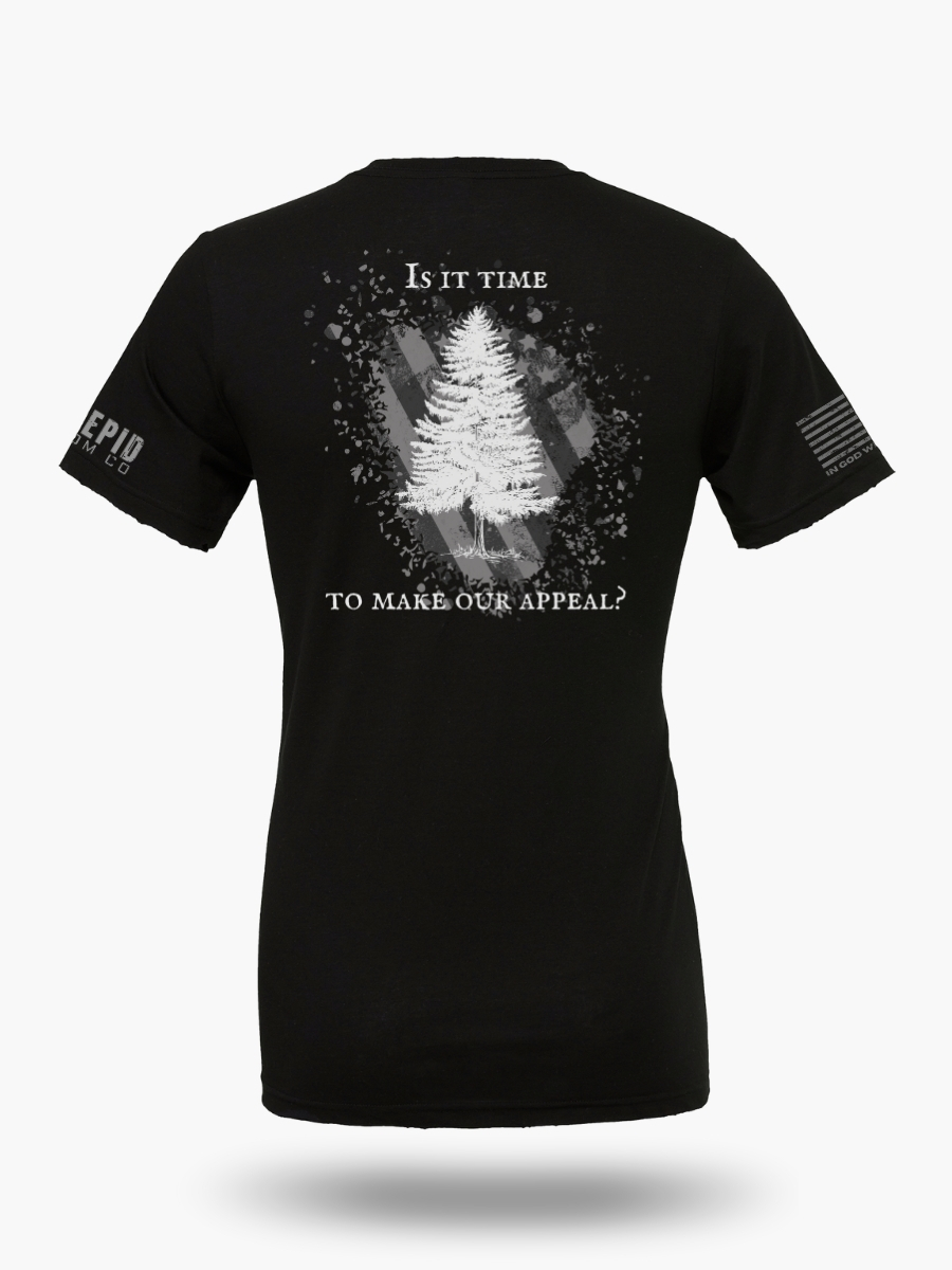 Appeal to Heaven flag design featuring a bold White Pine Tree over a distressed American flag background on black t-shirt. Historic patriotic graphic with strong revolutionary symbolism.