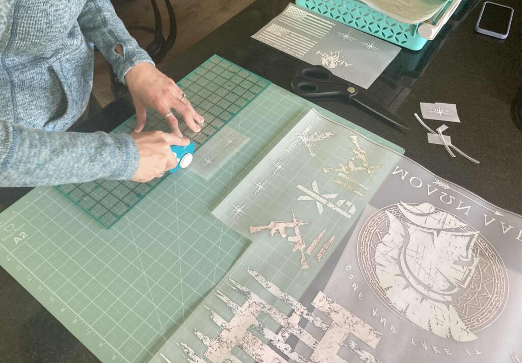 The founder of Intrepid Custom Co. cutting DTF film in a workshop, surrounded by tools and materials, showcasing the hands-on skill involved in our custom printing process.