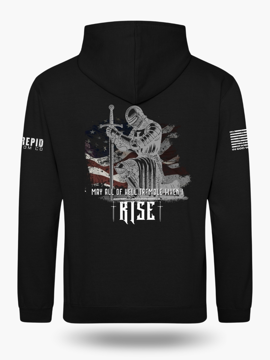 Back view of a black hoodie with a detailed graphic of a kneeling knight in armor holding a sword, set against an American flag background, and the text "MAY ALL OF HELL TREMBLE WHEN I RISE."