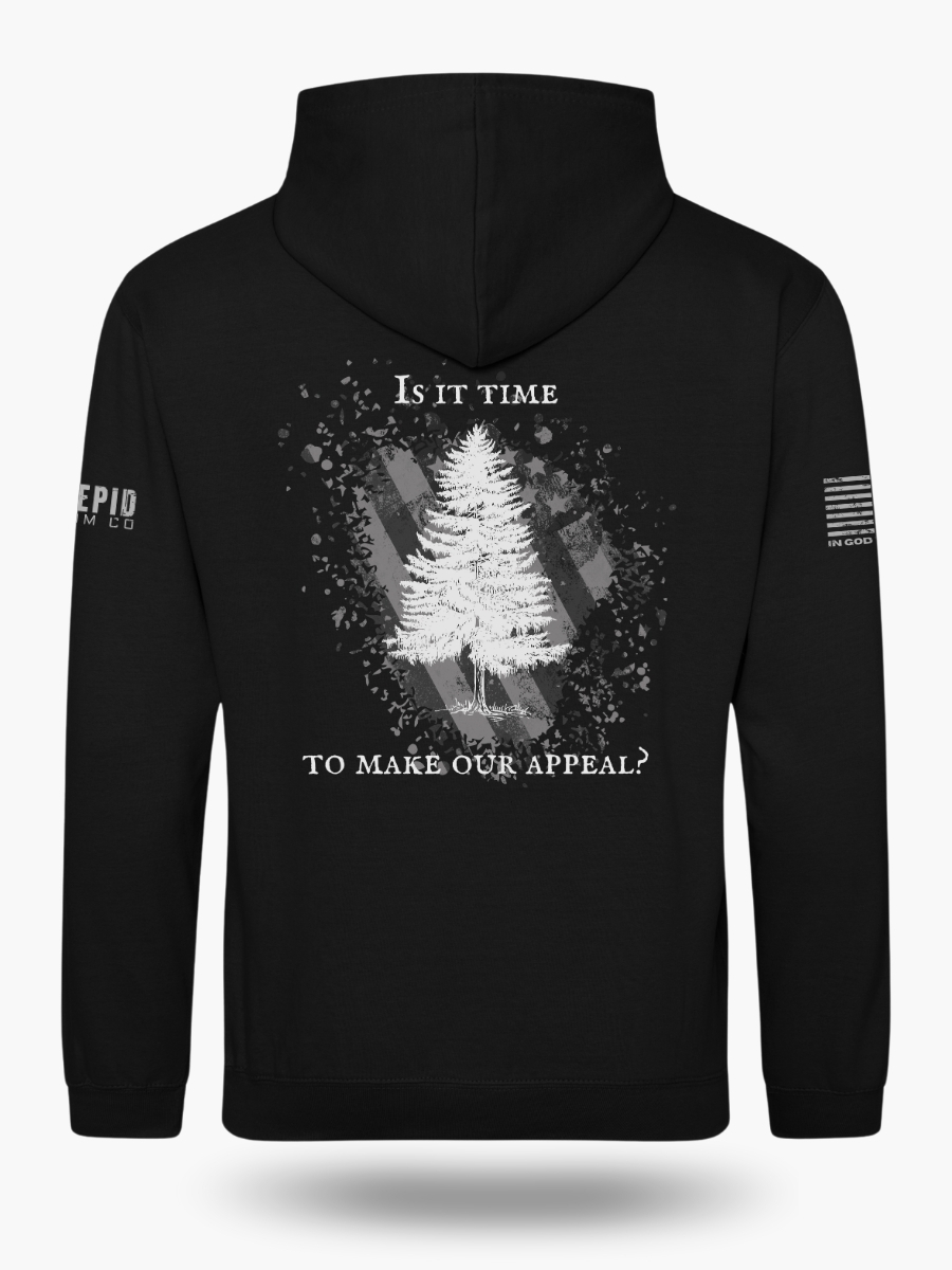 Black hoodie with Appeal to Heaven flag design featuring a bold White Pine Tree over a distressed American flag background. Historic patriotic graphic with strong revolutionary symbolism.