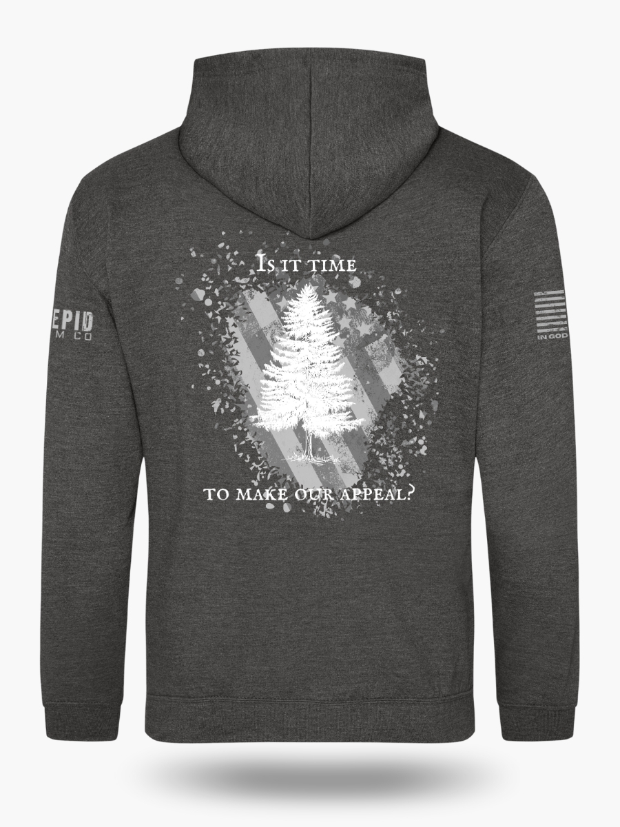 Dark heather grey hoodie with Appeal to Heaven flag design featuring a bold White Pine Tree over a distressed American flag background. Historic patriotic graphic with strong revolutionary symbolism.