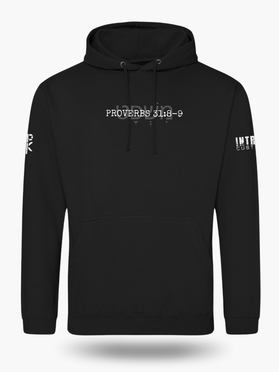 Front of black hoodie showing Proverbs 31:8&acirc;9 with the Hebrew word &times;&Ouml;&acute;&times;&copy;&Ouml;&deg;&times;&times;&curren;&Ouml;&cedil;&Ouml;&frac14;&times; behind it. Subtle, meaningful Christian design focused on biblical justice.
