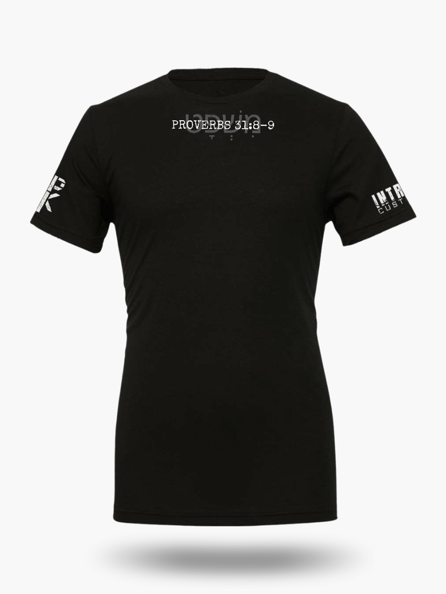 Front of black t-shirt featuring Proverbs 31:8&acirc;9 with the Hebrew word &times;&Ouml;&acute;&times;&copy;&Ouml;&deg;&times;&times;&curren;&Ouml;&cedil;&Ouml;&frac14;&times; in the background. Clean, minimalist Christian design emphasizing biblical justice.